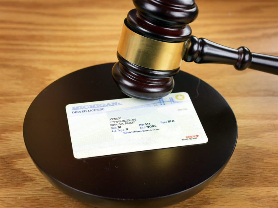 Michigan driver’s license next to a gavel symbolizing the laws regarding a hardship license