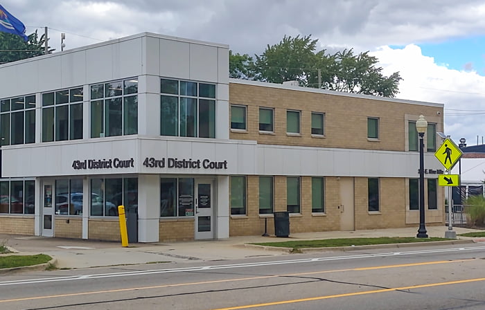 Front entrance to the 43rd District Court in Ferndale. The courthouse is a two story brick building along the road.