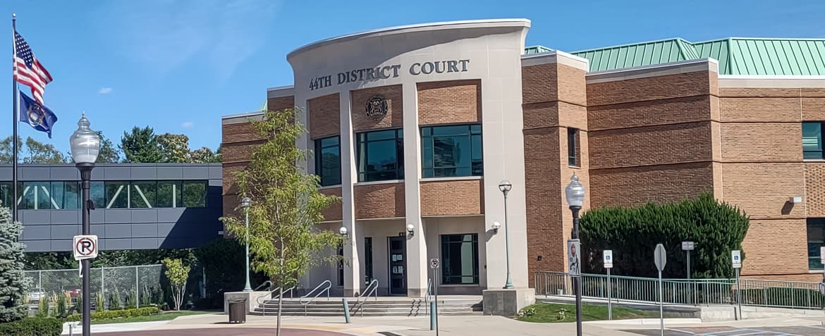 Front entrance to the 44th District Court in Royal Oak. The court house is a tall brick building with a small staircase and wheelchair accessible ramp leading up to it