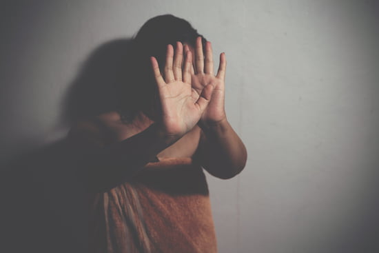 A shadowy woman with her hands up indicating the Assault and Battery practice area