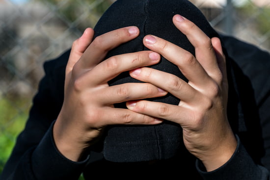 Young teen with his head in his hands looking concerned indicating the juvenile defense practice area