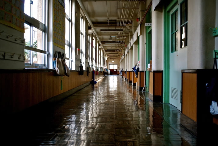 School hallway with backpacks hanging across the classrooms