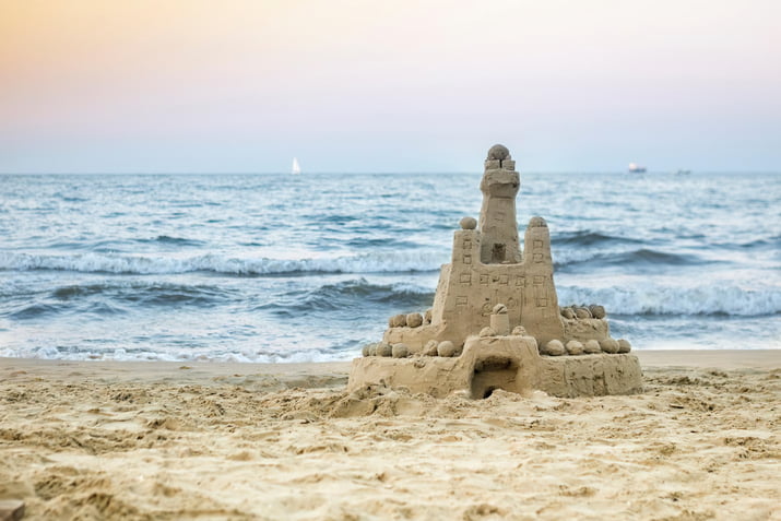 A sandcastle is shown on a beach at sunset, symbolizing the castle doctrine in Michigan