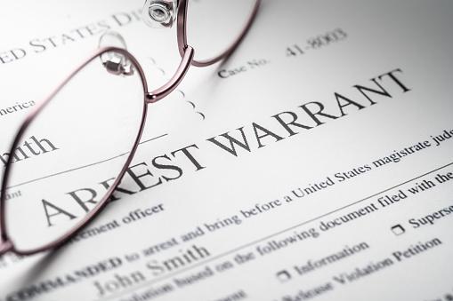 Featured: Arrest Warrant with pair of glasses on top - Criminal Process in Michigan