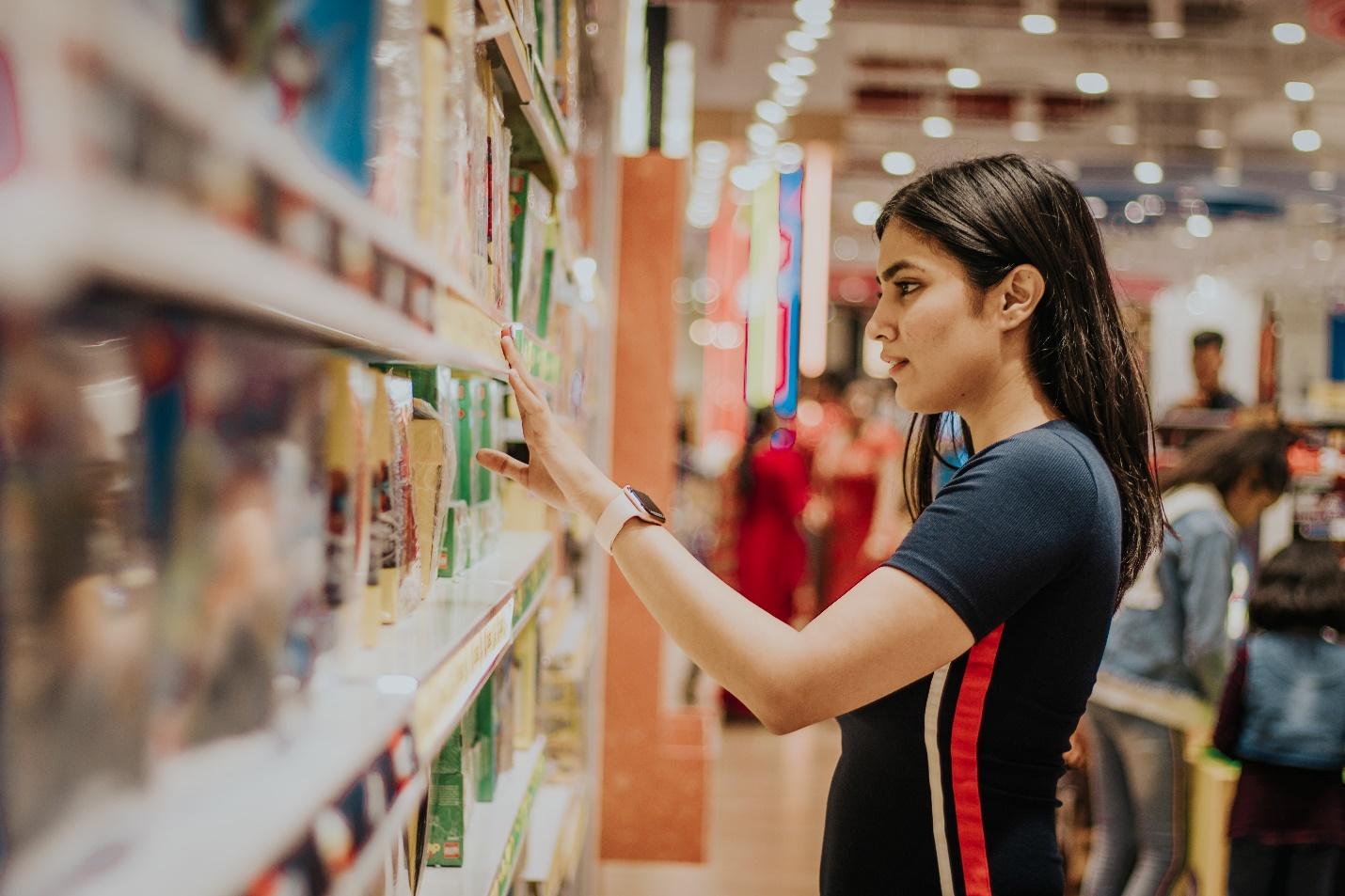 Featured: Female touching an item on shelf-Can You Defend Against Michigan Shoplifting Charges?