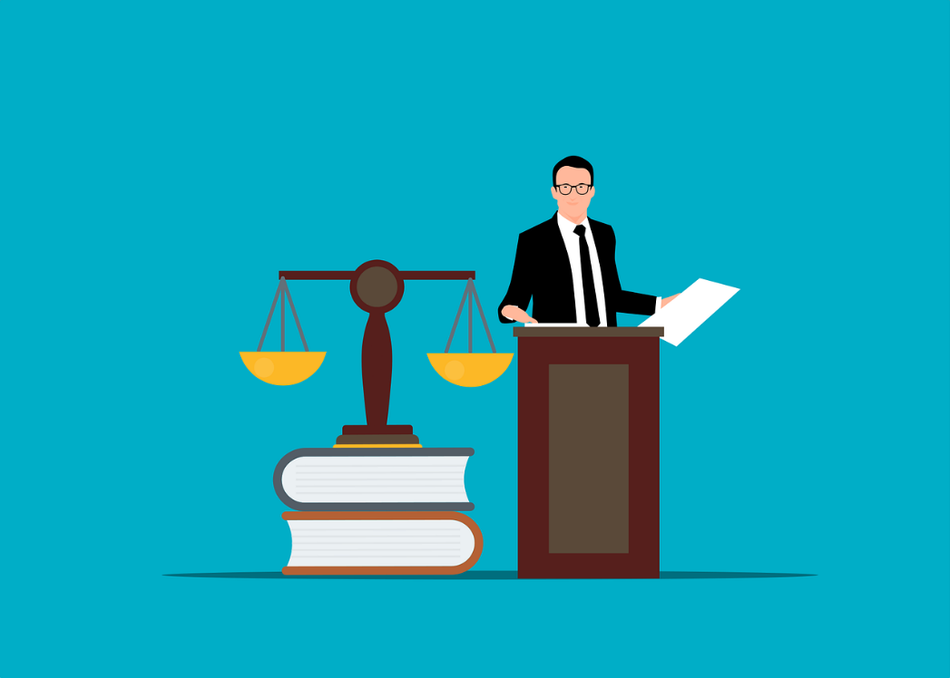 Featured: Attorney standing at lectern holding documents with justice scales to the side-Michigan Federal Drug Classifications