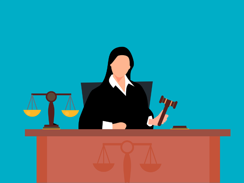 Featured: Female judge sitting at bench holding a gavel with justice scales on side- Michigan Indecent Exposure Lawyer