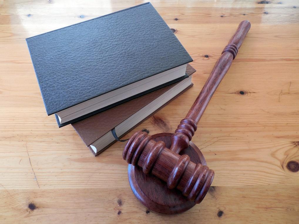 Featured: Law books and judges gavel on wooden desk= Miranda Rights in Michigan