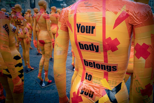 Featured: Sexual assault activists wearing 'your body belongs to you' slogan on bright yellow bodywear- Sexual Assault Lawyer in Michigan