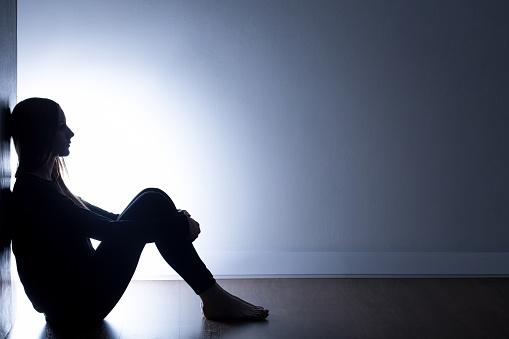 Featured: Female victim sitting on floor.- Rape Laws in Michigan