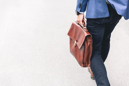 Featured: Attorney in suit holding a brown briefcase- Public Defender Vs Private Attorney