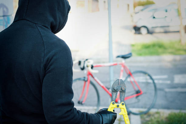 Featured: Hooded thief with tool waiting to steal red bike- Receiving Stolen Property in Michigan