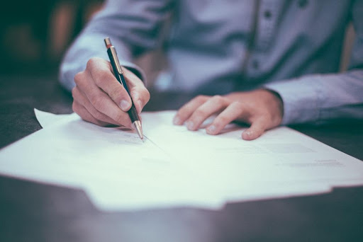 Male writing notes at desk - Preparing for a Criminal Defense Case Evaluation