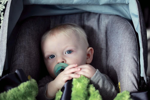 Featured: Infant with pacifier in car-seat- Why Drinking and transporting kids is a no-go in Michigan